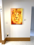 Acrylic painting of a lion's face on an easel with a warm background in a gallery setting